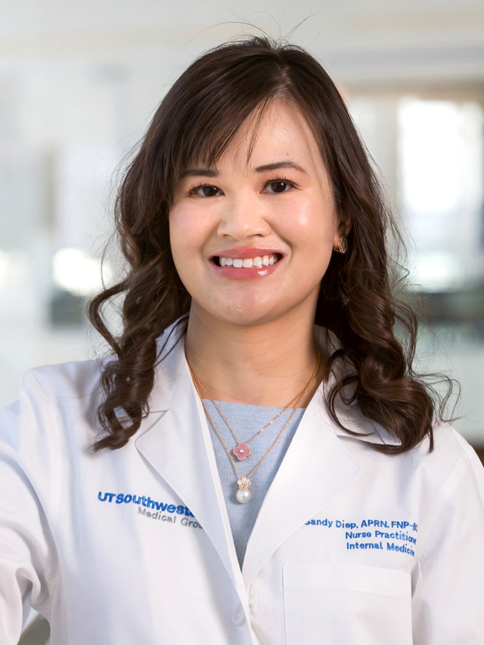 Woman in pale blue shirt and white lab coat, smiling