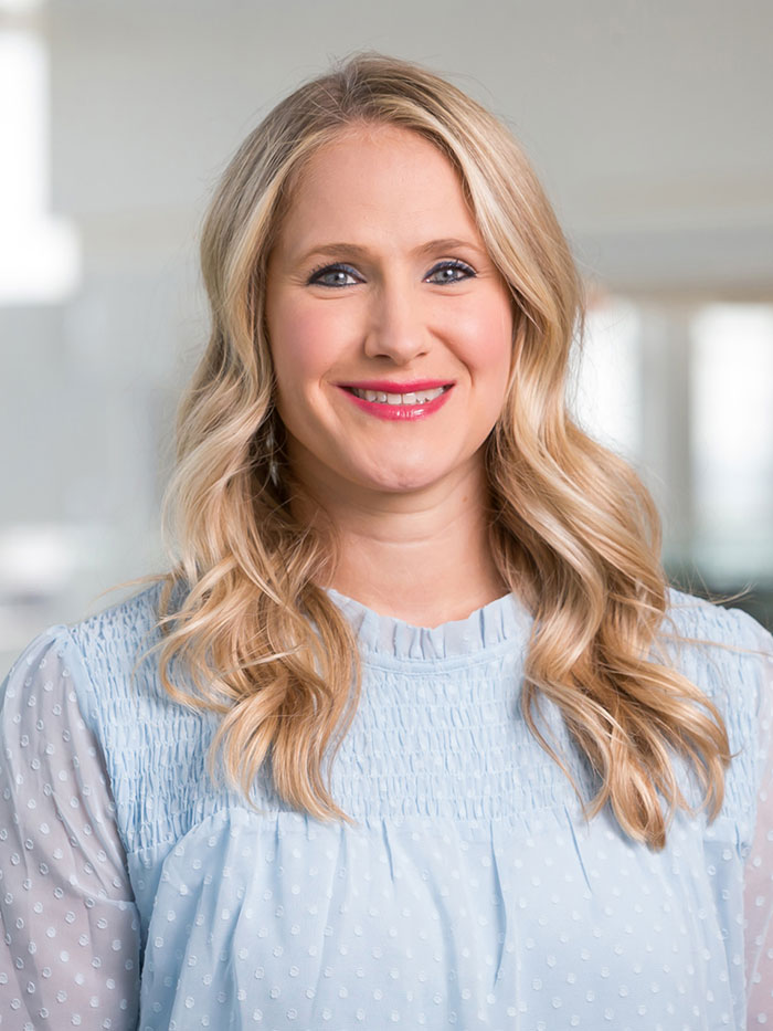 Woman with blonde hair, light blue long-sleeved blouse