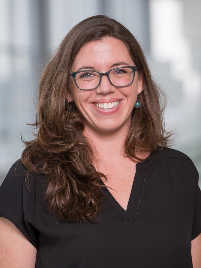 Woman with brown hair, black glasses