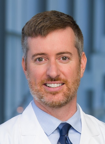 Man wearing a lab coat and blue tie