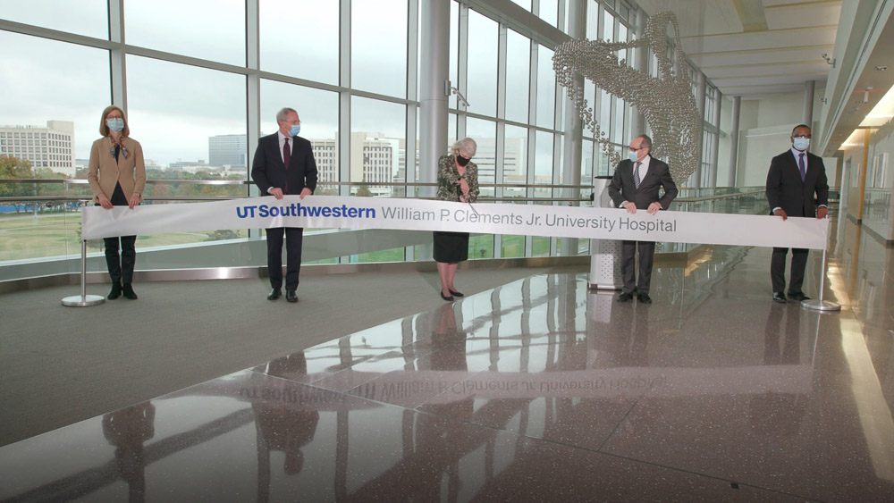 Three people spread out, cutting large ribbon