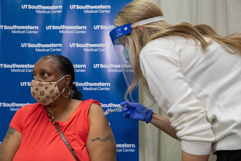 Woman with rolled up sleeve receiving a shot in the arm