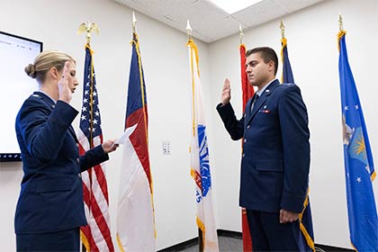 two military service members in uniform with raised right hands