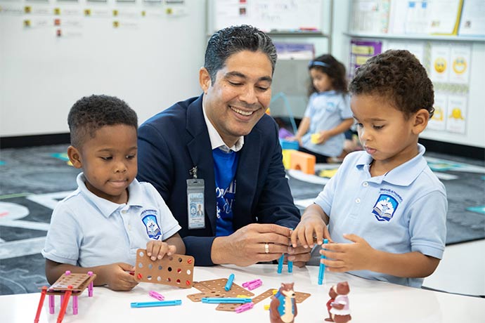 man sitting between two students at table 