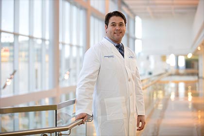 man wearing white lab coat, standing