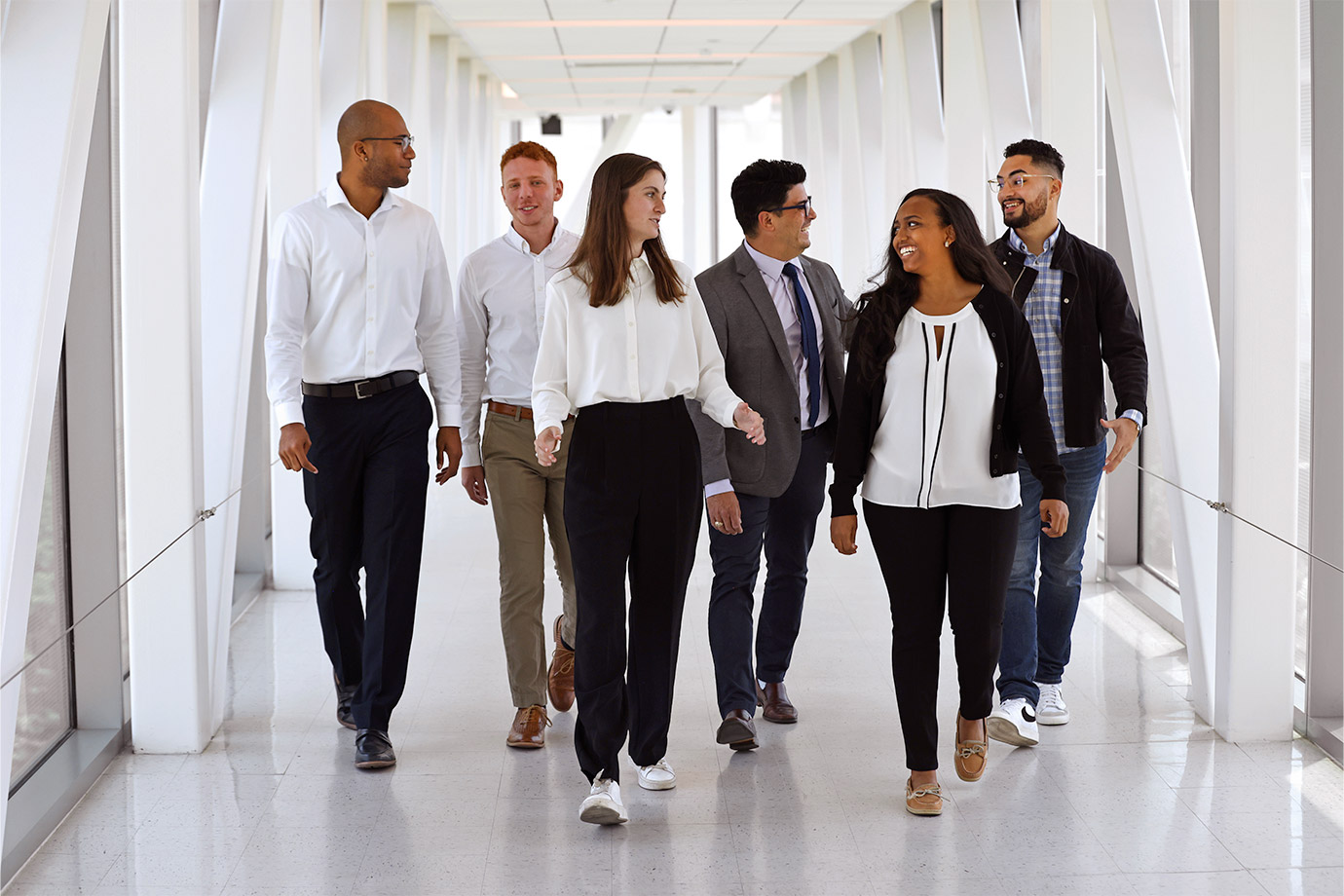 man in suit walking with scholars