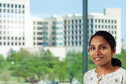 woman in floral print blouse in front of building background