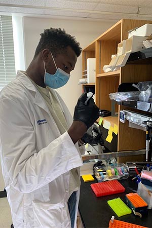 man in blue shirt holding test tube