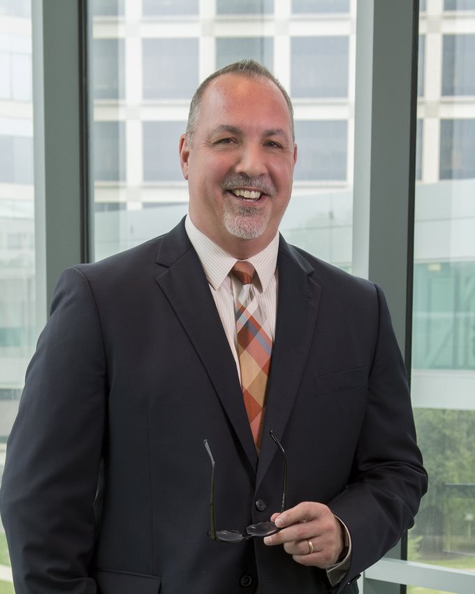 man in dark grey suit with plaid tie