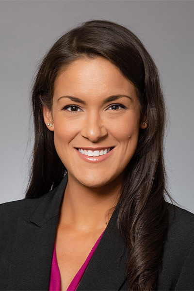 Woman wearing gray blazer with fuchsia blouse