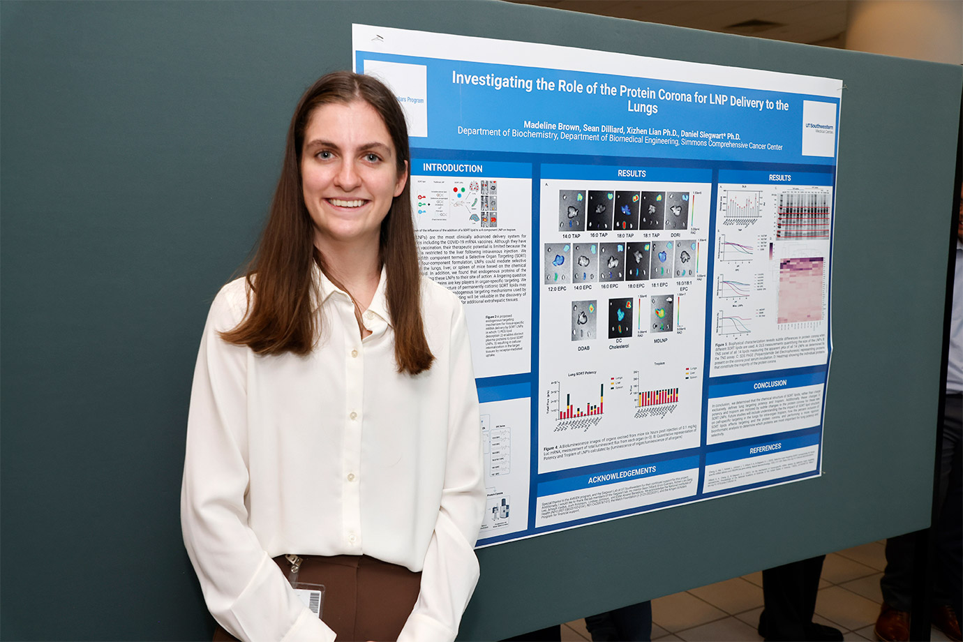 woman in white blouse standing in front of poster