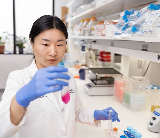 woman in lab holding test tubes