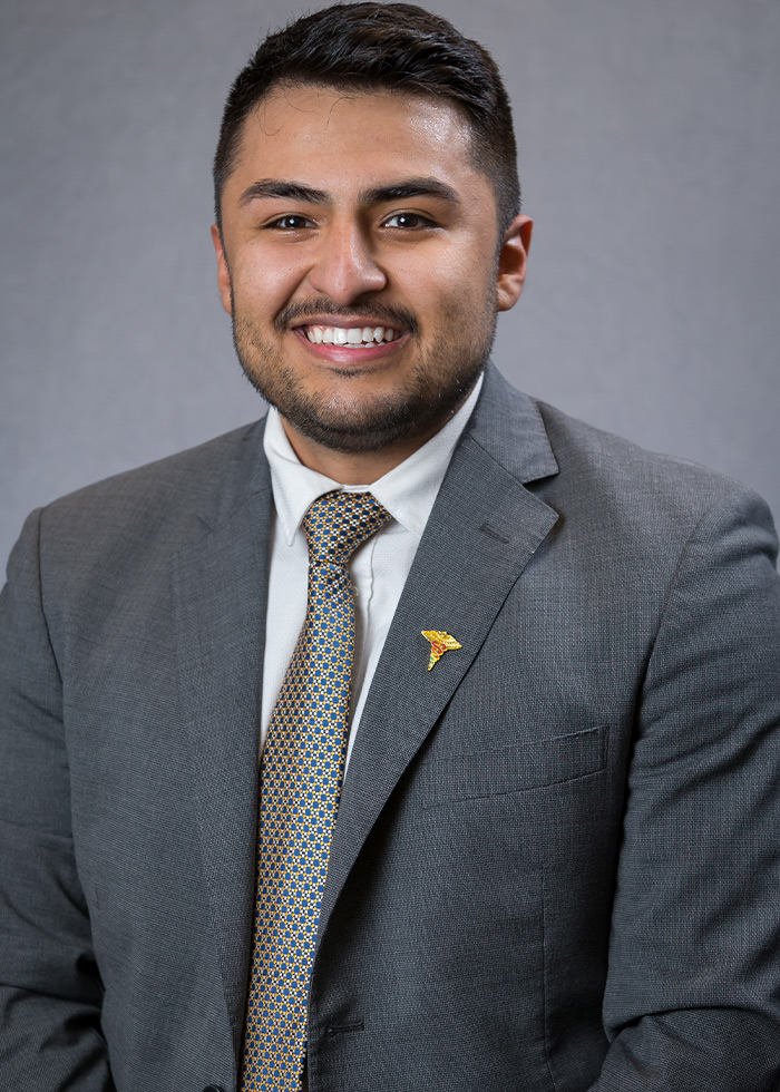 Man with close cropped hair wearing a gray suit