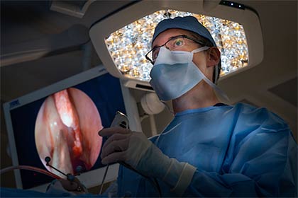 Man wearing blue surgical scrubs during surgery