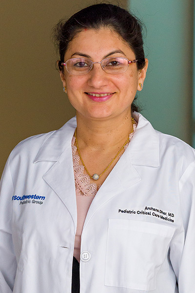 woman in white lab coat, dark hair, colorful background