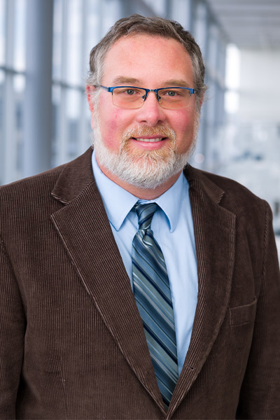 man in blue shirt, paisley tie, brown jacket