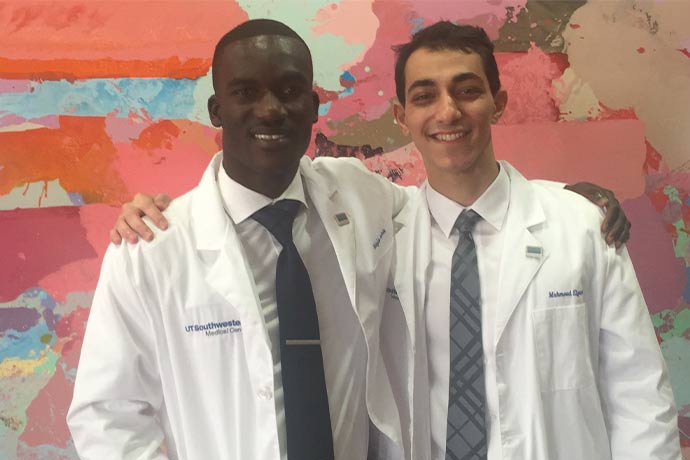 two men side-by-side in white lab coats