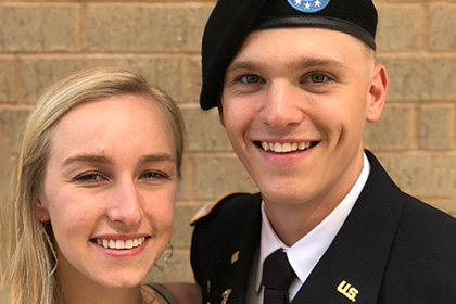 James in uniform standing with blond woman