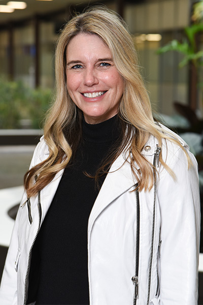 woman in cream coat and black turtleneck, dark hair