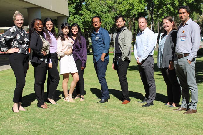 group of researchers standing outside on grass