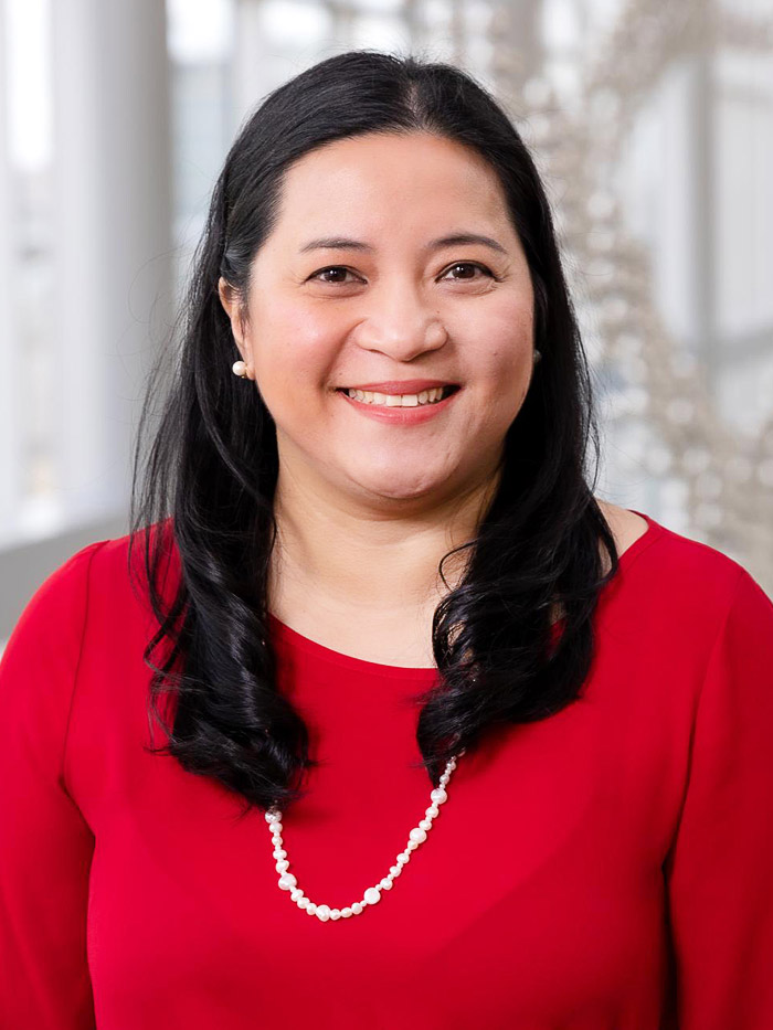 woman with dark hair, red shirt, white necklace