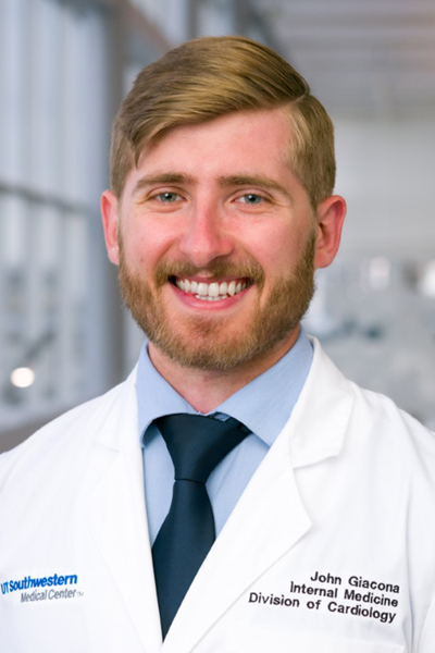 Smiling man with blond  hair, beard and mustache, wearing a lab coat.