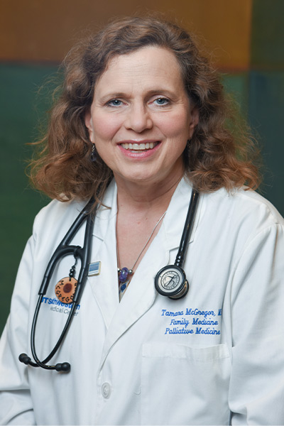 woman with reddish brown hair wearing white lab coat
