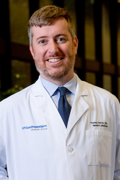 man with reddish hair in white lab coat