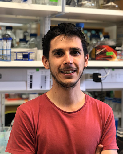 man with dark hair and red shirt in lab