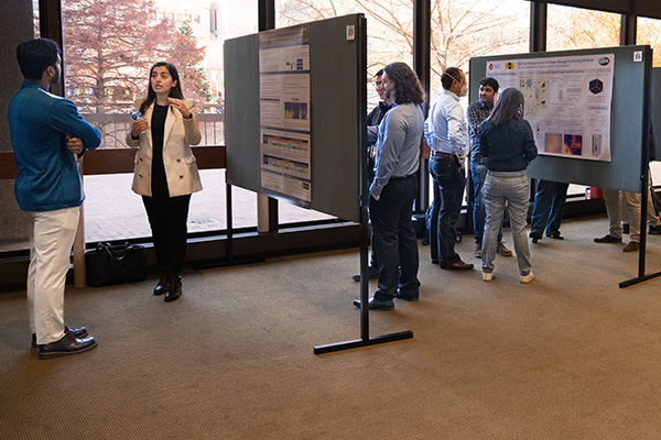 Audience members walk around the lobby viewing posters.