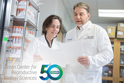 Man and woman looking at paper, standing in a lab. Copy - Green Center for Reproductive Biology Sciences 50 Years