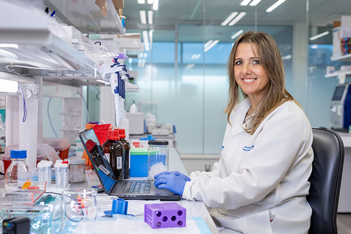 woman wearing white lab coat seated in research lab