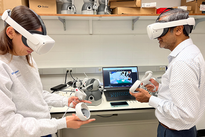 student researcher left and male professor wear virtual reality goggles to test simulation equipment in lab