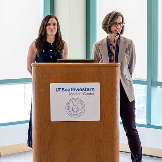 Two women speaking at a podium at UTSW.