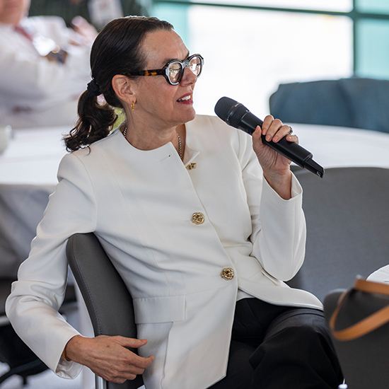 Seated woman holding a microphone.