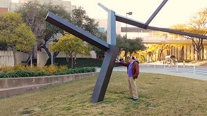 Man admiring a bronze statue.