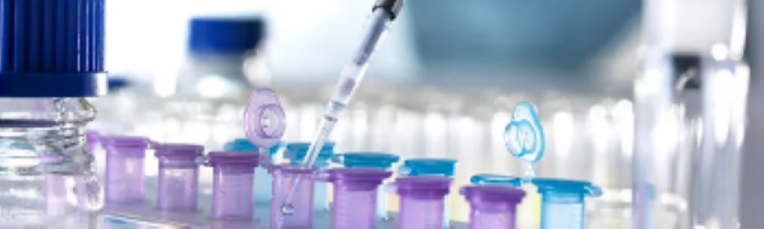 syringe over test vials in lab