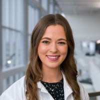 Caucasian woman wearing white lab coat