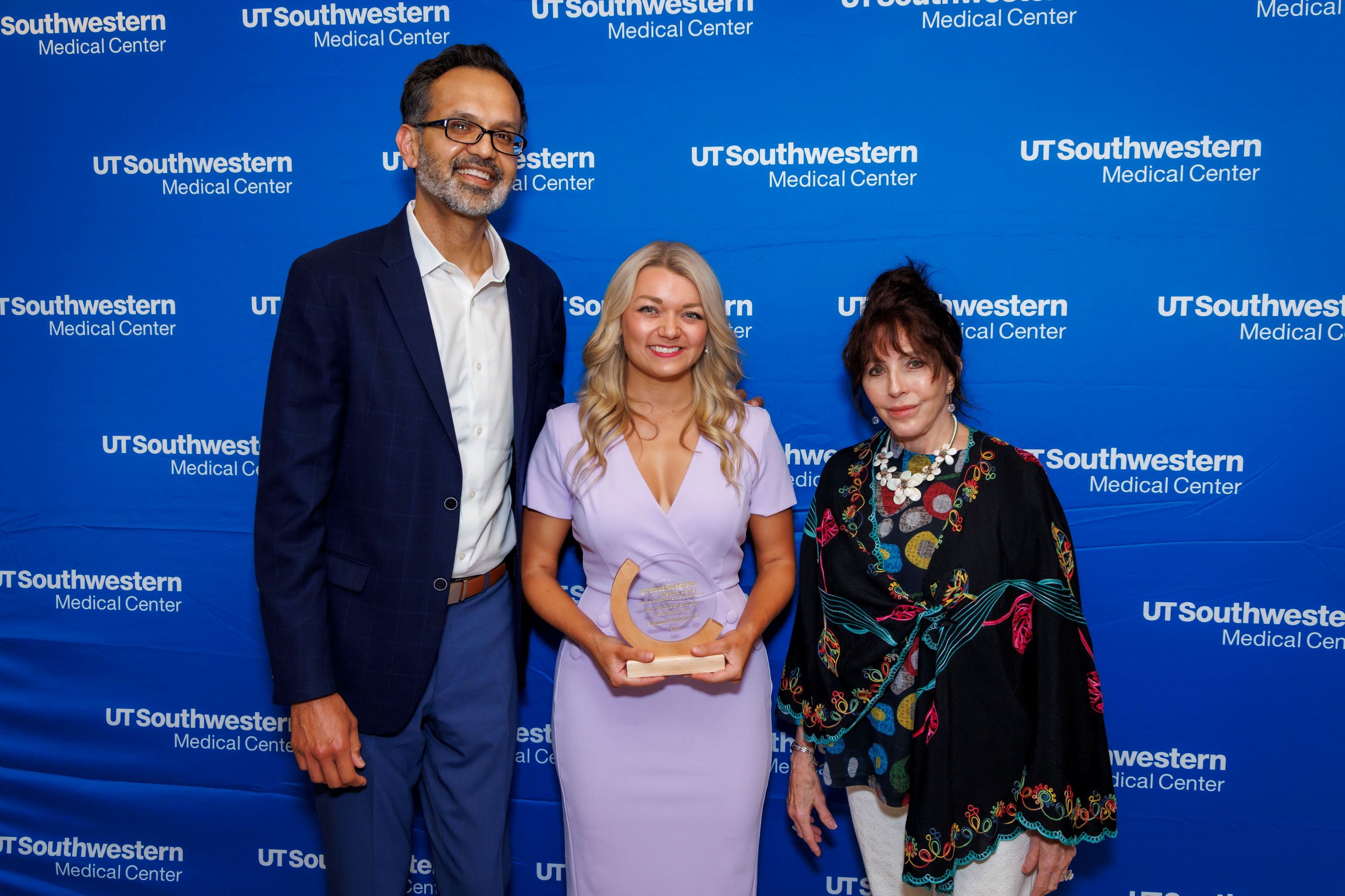 Shannon Paquette, M.D., holding award with Ravi Bhoja, M.D. and Caroline Cammack
