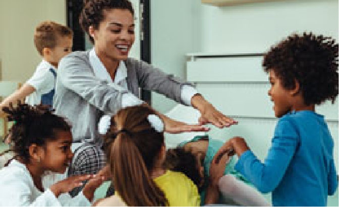 Female teacher playing with toddlers in a classroom