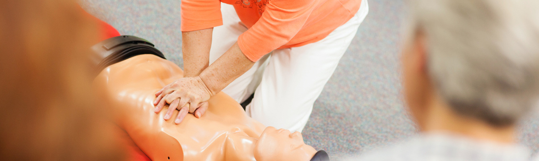 A woman doing chest compressions on a training model