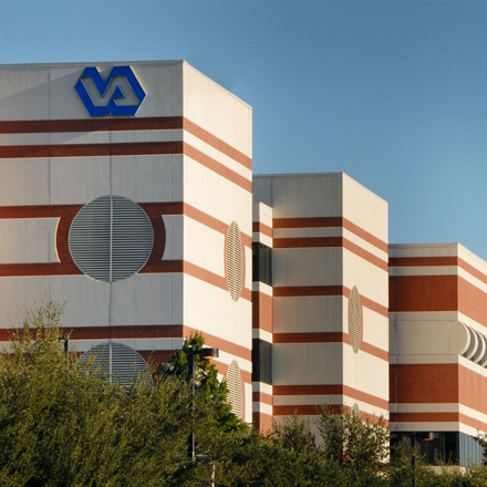 Building with brown lines, tan stone, and round grates