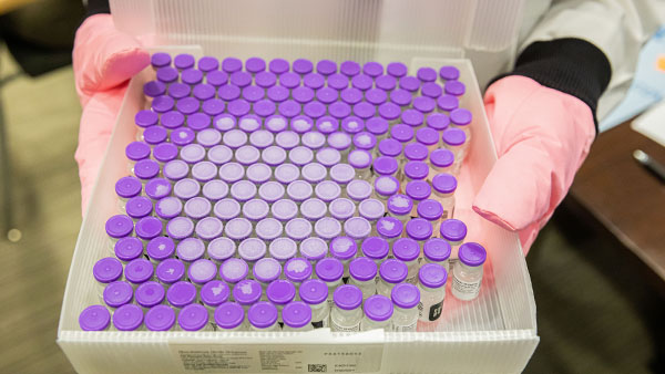 hand holding tray of medical samples in vials