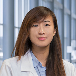 Dr. Emily Wong wearing a white coat, standing in the CUH lobby