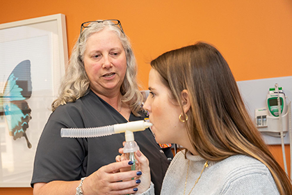 nurse assisting patient with asthma medication tube