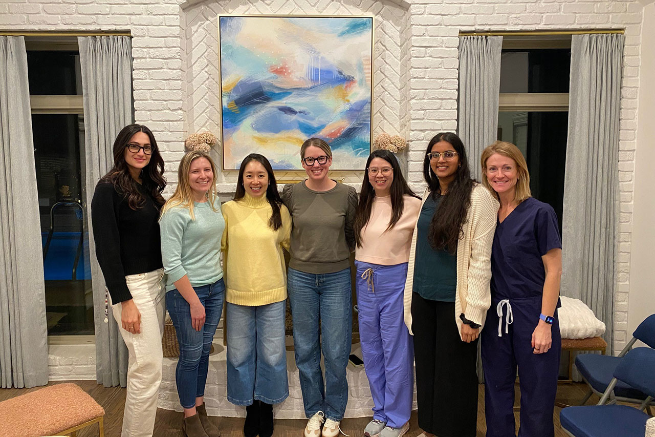 a group of fellows in front of a colorful painting