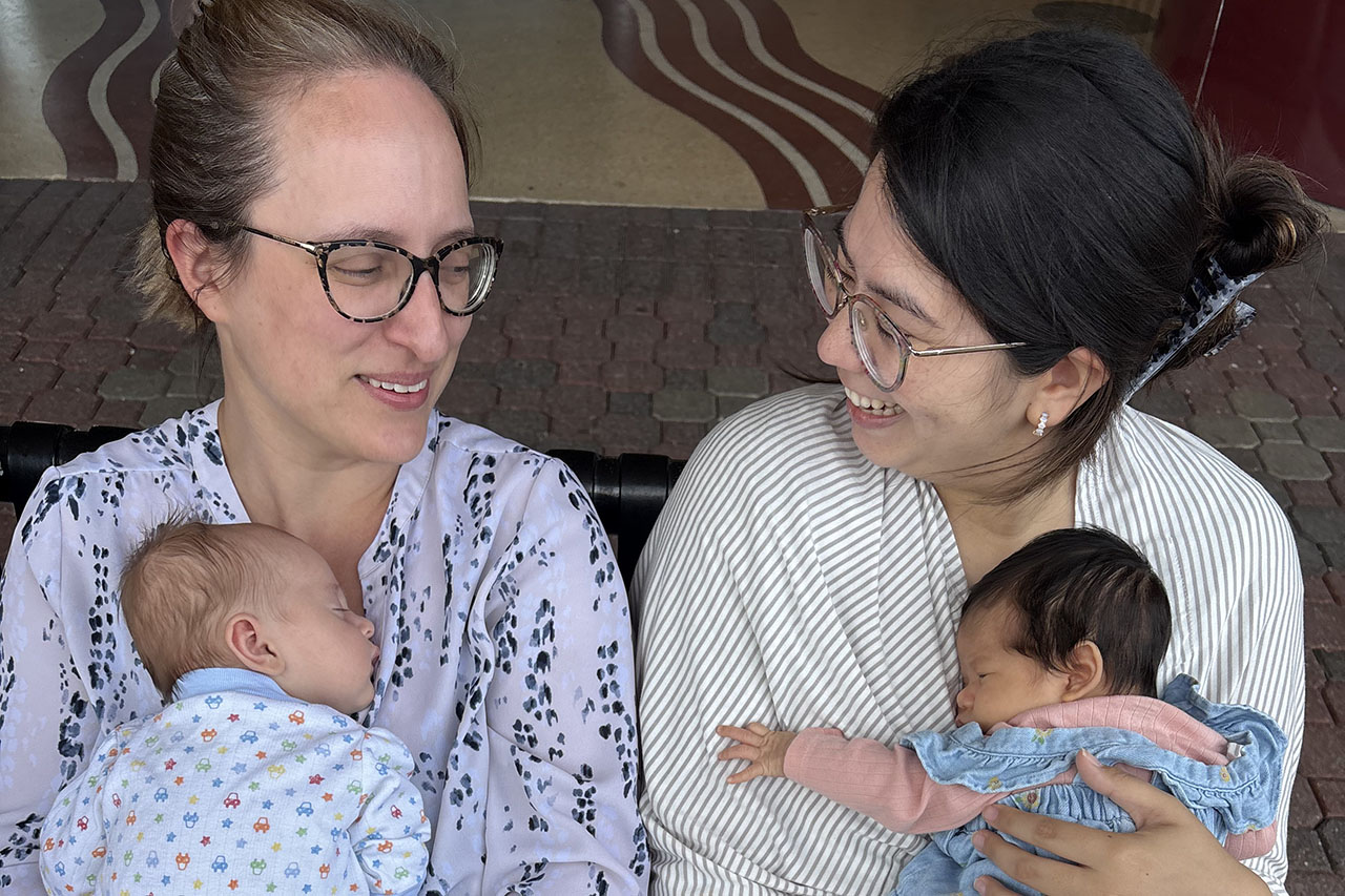 A close-up photo of two women holding babies