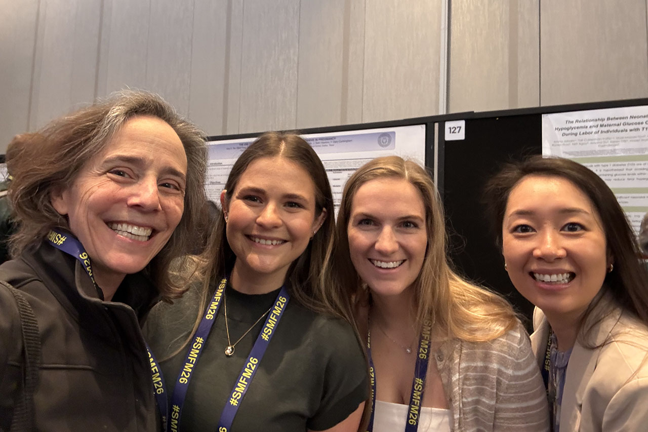 Four women in front of conference posters
