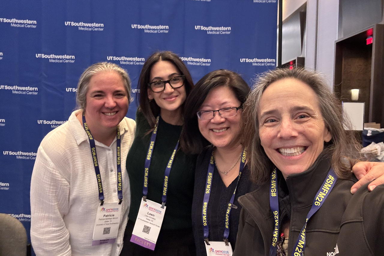 Four women wearing lanyards at SMFM 26