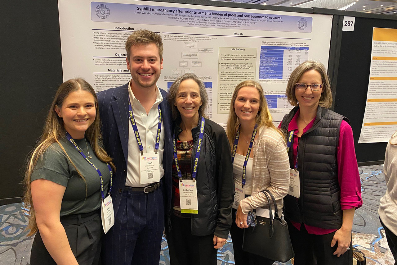 five people in front of conference posters